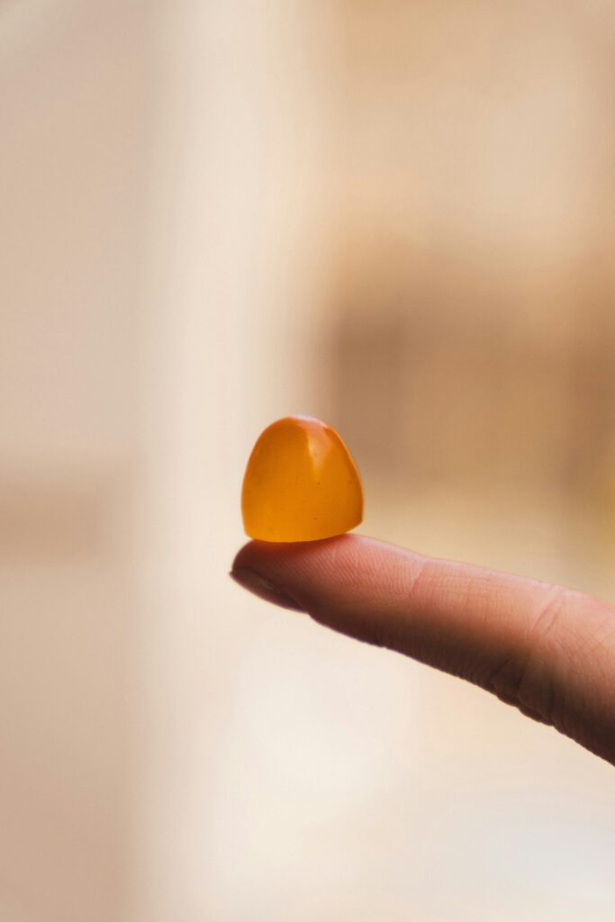 Privacy Policy – Kids Protein Gummies 1 A close-up of a single orange protein gummy balanced on the tip of a finger, highlighting its healthy, real food ingredients.