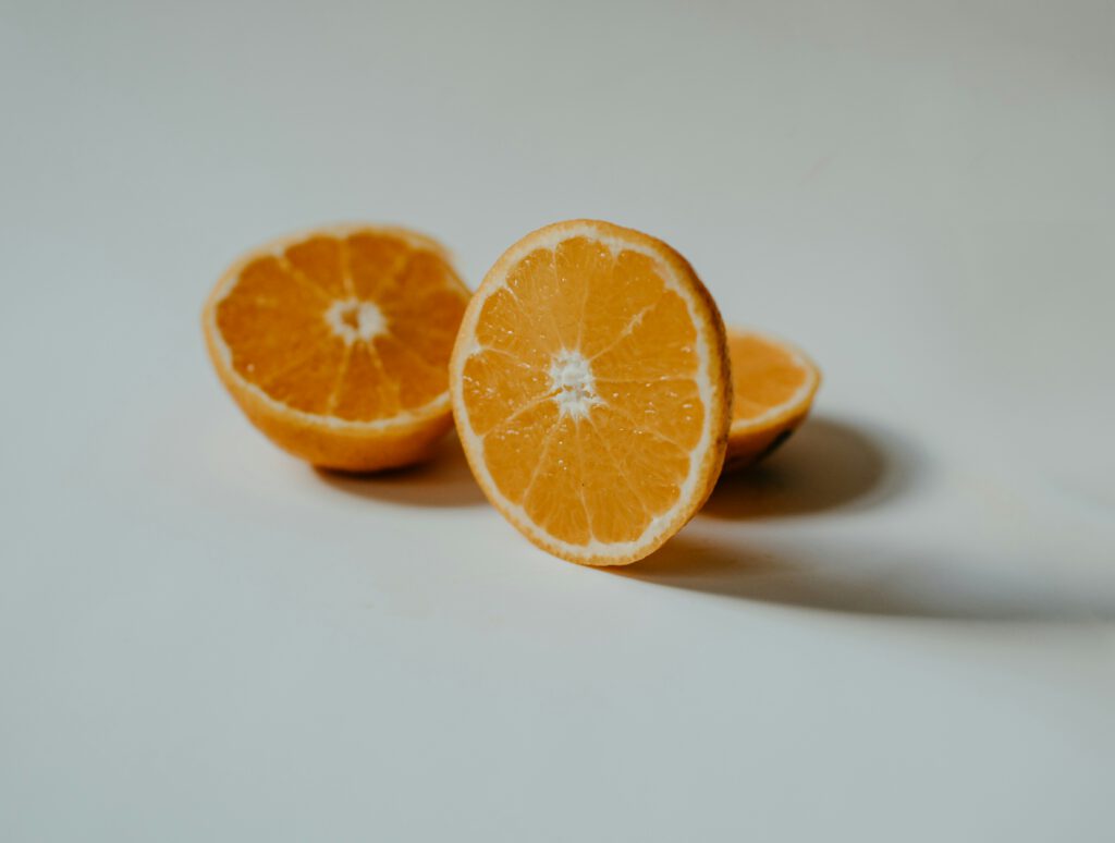 The Role of Kids Vitamin C in Nutrition and Protein Synthesis 1 Two fresh orange halves on a clean white background